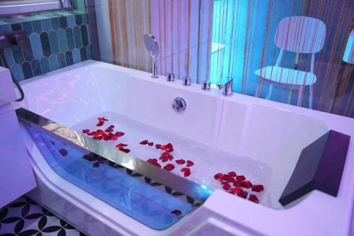 a bath tub with red flowers in it at Haven Hotel in Ho Chi Minh City
