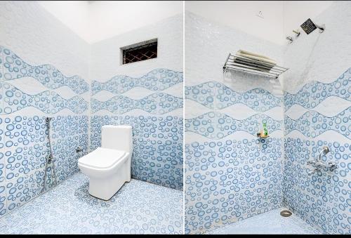a bathroom with a toilet and blue and white tiles at Grand Ayushmaan - Best Hotel in Jabalpur in Jabalpur