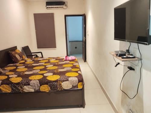 a bedroom with a bed and a flat screen tv at AB Merridien in Coimbatore