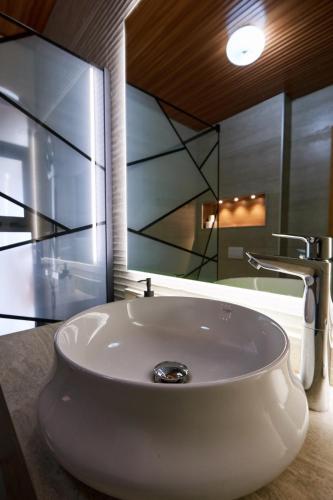 a white sink in a bathroom with a mirror at Hôtel Touraco in Assinie