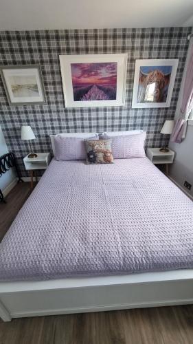 a large bed in a bedroom with two tables at Innisfail Edi - double room with private bathroom in Edinburgh