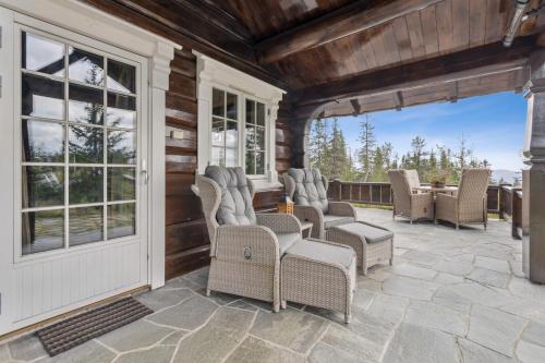 a patio with wicker chairs and tables on a house at Orreleiken in Åmot