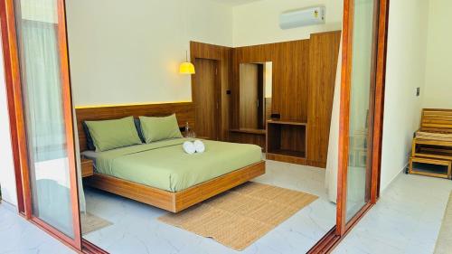 a bedroom with a bed and a mirror at Encore by Serenity in Hampāpura