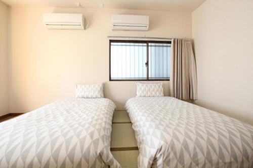 two beds in a room with a window at 水之道 in Osaka