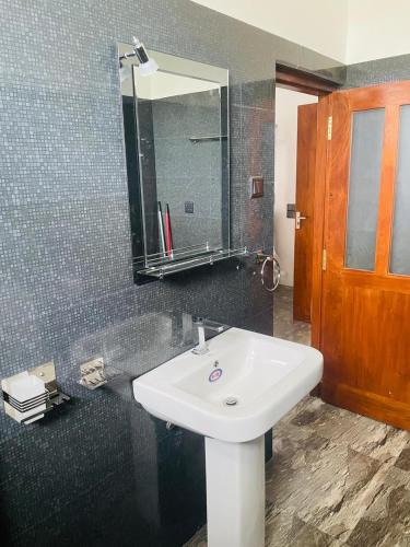 a bathroom with a white sink and a mirror at Elysian Riverside in Weligama