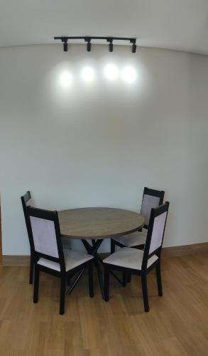 a wooden table with two chairs and a table with lights at Ótima localização in Imperatriz