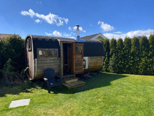 an old rv parked in a yard with a blue chair at Pool & Sauna Retreat - Private Studio Apartment Porsgrunn in Porsgrunn