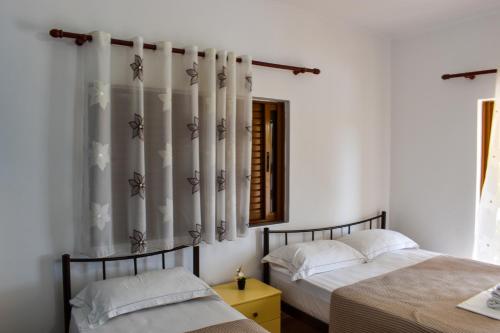 a bedroom with two beds and a window at Kompleks Angjelo in Lukovë