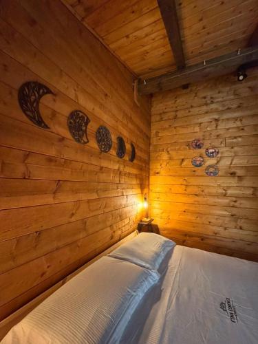 a bedroom with a bed in a wooden wall at Etna Essence Chalet in Trecastagni