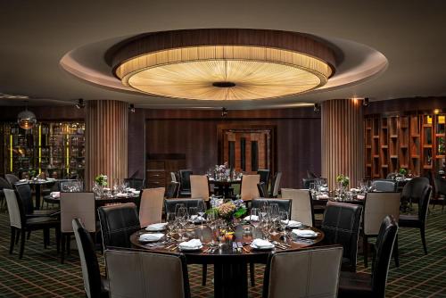 a dining room with tables and chairs and a large chandelier at Killarney Towers Hotel & Leisure Centre in Killarney