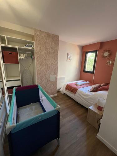 a bedroom with a bed and a crib in it at Les jardins de la Méditerranée in Six-Fours-les-Plages