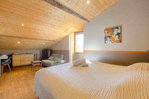 a bedroom with a white bed and a wooden ceiling at La Vie de Château, proche Lyon in Bessenay