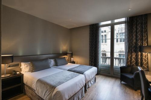 Ένα ή περισσότερα κρεβάτια σε δωμάτιο στο Catalonia Portal de l'Angel