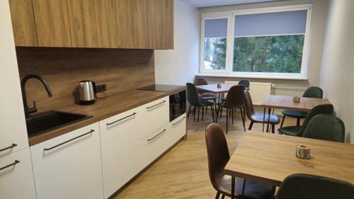 a kitchen with a table and chairs and a table and a kitchen with a counter at Nemunėlio vitražai in Nemunėlio Radviliškis