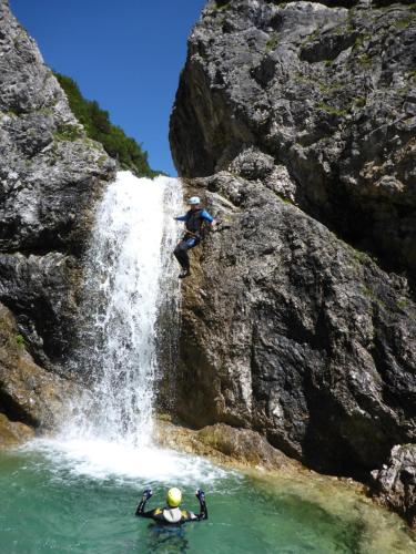 two people are rappelling from a waterfall at Apart Lechtraum in Stanzach