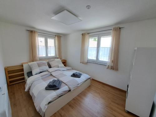 a bedroom with a bed with two pairs of shoes on it at Gästehaus Kienle in Rot an der Rot
