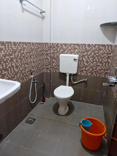 a bathroom with a toilet and a sink and a bucket at Durga Beach Resort in Parxem