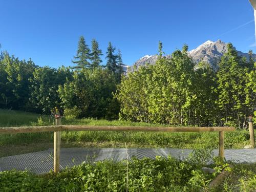 a wooden fence in a field with mountains in the background at Studio station Puy-Saint-Vincent in Puy-Saint-Vincent