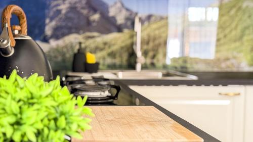 a kitchen with a counter top with a chopping board at Domek Zyngierka Tatra View - balia I sauna na wyłączność in Bańska Wyżna
