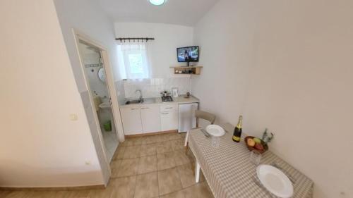 a small kitchen with a table and a sink at Cozy and practical studio in avonija in Murine