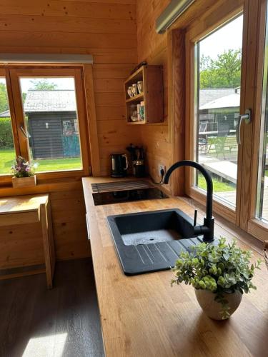 a kitchen with a sink in a log cabin at Greenwood Chalet in Ottershaw