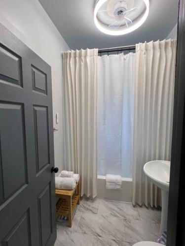 a bathroom with a white shower curtain and a sink at Midtown Detroit Upper Retreat in Detroit