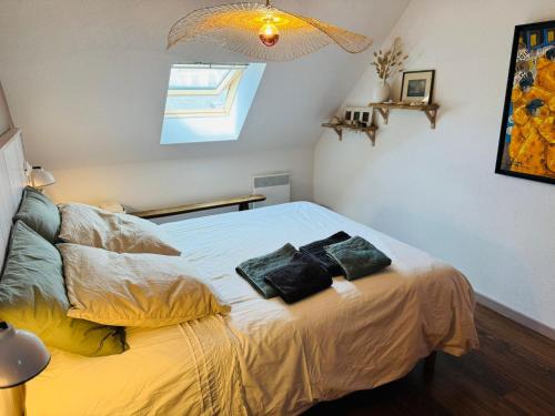 a bedroom with a bed with two pillows on it at Appartement duplex vue mer in Audierne