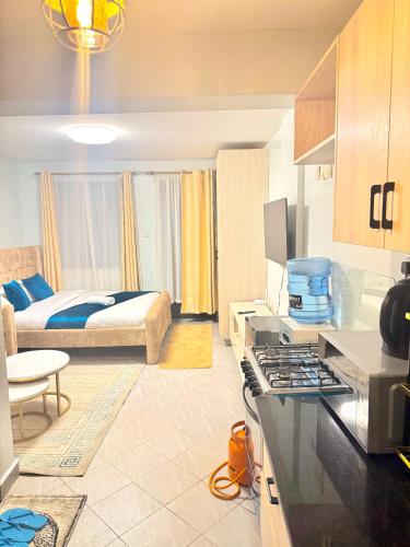 a room with a bed and a kitchen with a stove at Bliss Homes in Nairobi