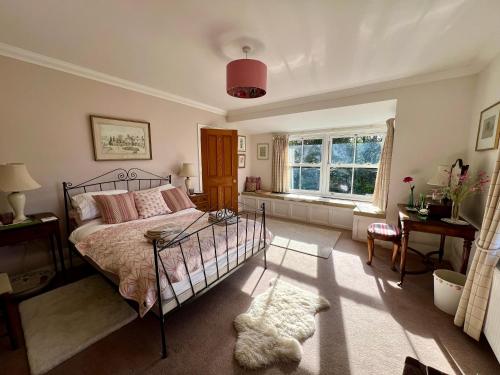 a bedroom with a bed and a window at Elmsleigh in Marhamchurch