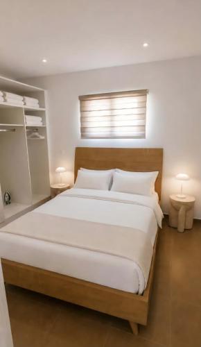 a bedroom with a large white bed with two lamps at Aelia House Kefalos - Cozy & Quiet in Kos