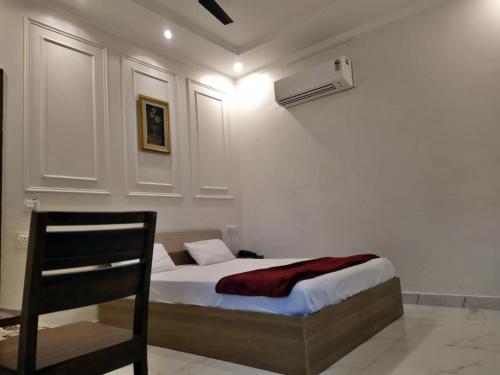 a bedroom with a bed and a chair in it at Hotel Sahajtam Inn in Sonīpat