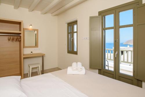 a bedroom with a bed with a view of the ocean at "Araklos" Summer houses in Aegiali