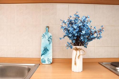 a vase of blue flowers sitting next to a sink at Apartments Katušić in Cavtat
