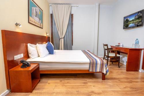 a bedroom with a bed with a desk and a table at Villa Nazareth - Boutique hotel in a central location in Nazareth