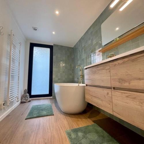 a large bathroom with a tub and a window at Deep Forest in Bastogne