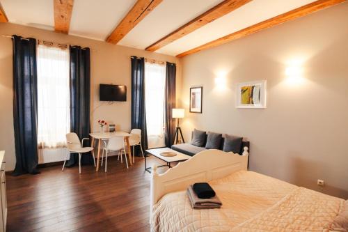 a bedroom with a bed and a couch and a table at Enjoy Old Town vibes in 1716 Laipu Residence with 4 stylish Apartments and 1 Penthouse in Riga