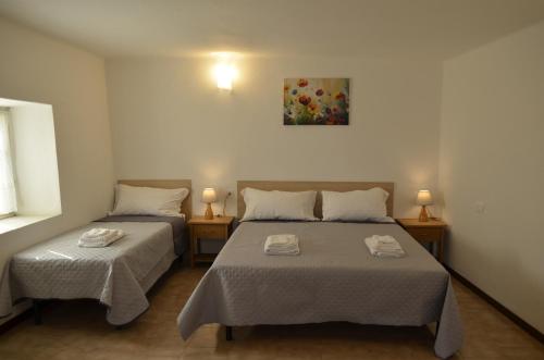 ein Schlafzimmer mit zwei Betten, zwei Lampen und einem Gemälde in der Unterkunft Al Canto in Rota d'Imagna