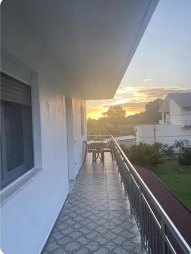 a balcony with a table and a sunset in the background at Guesthouse Oasis in Baks-Rrjoll