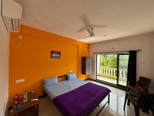 a bedroom with a purple bed and a large window at Durga Beach Resort in Parxem