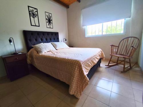 a bedroom with a bed and a chair and a window at Casa Nuup in Río Tercero