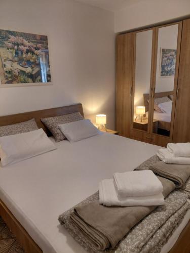 ein Schlafzimmer mit einem großen weißen Bett, auf dem Handtücher liegen in der Unterkunft Joy4You in Čilipi