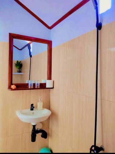 a bathroom with a sink and a mirror at Bunaken Paradise Beach Homestay in Bunaken