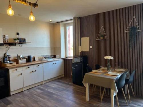 a kitchen with a table with chairs and a table and a kitchen with a table at L'escapade du temps in Les Épesses