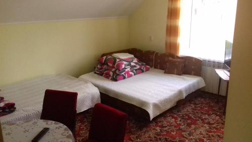 a room with two beds and a table and a window at Noclegi Renata in Solina