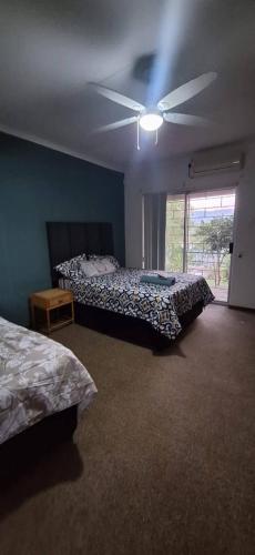 a bedroom with two beds and a ceiling fan at HL Self-catering Accommodation in Bonnievale