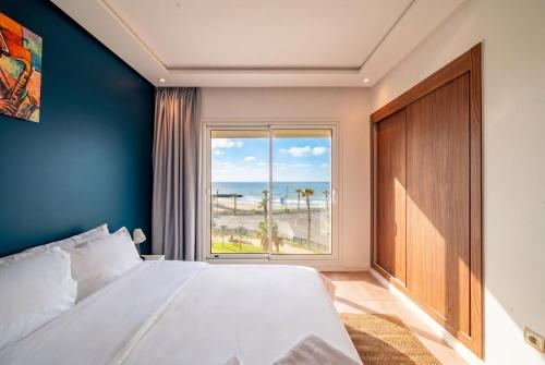 a bedroom with a large bed and a large window at Atlantic Blue 3BR Ocean View, Rabat Corniche in Rabat