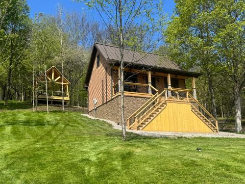 a small house with a large porch and a largeintend at The Old Orchard Cottage in LaFayette