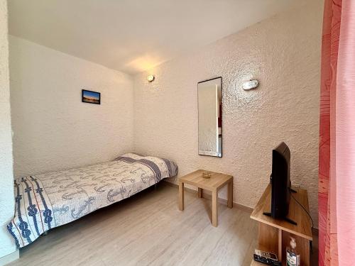 a small bedroom with a bed and a tv at Villa Gromaca in Omišalj