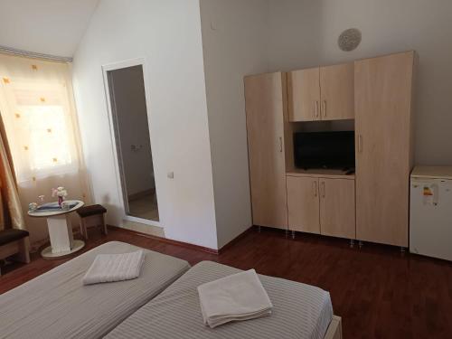 a bedroom with a bed and a tv and cabinets at Căbănuțele Rotunda in Băile Herculane