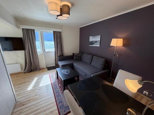 a living room with a couch and a table at Hofslund Apartments in Sogndal